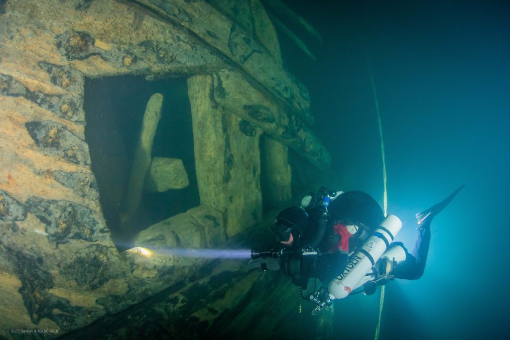 Diver peaks into the side of the shipwreck of the Mars. 