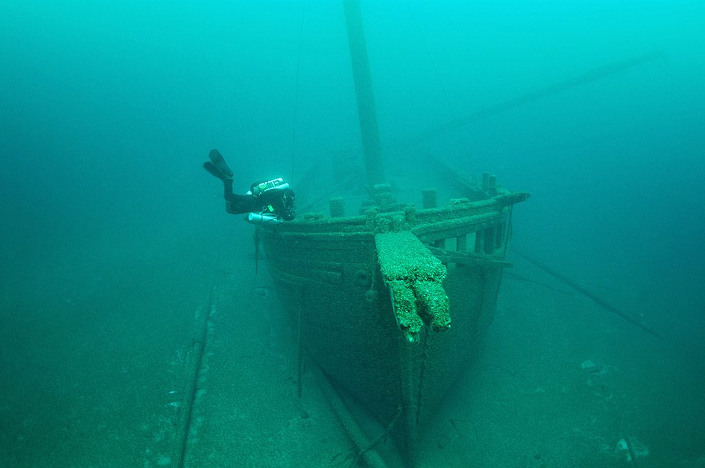 An archaeologist investigates the bow of the WALTER B. ALLEN shipwreck in Lake Michigan. 